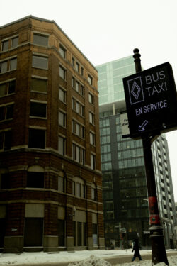 Bus taxi sign with building across the street